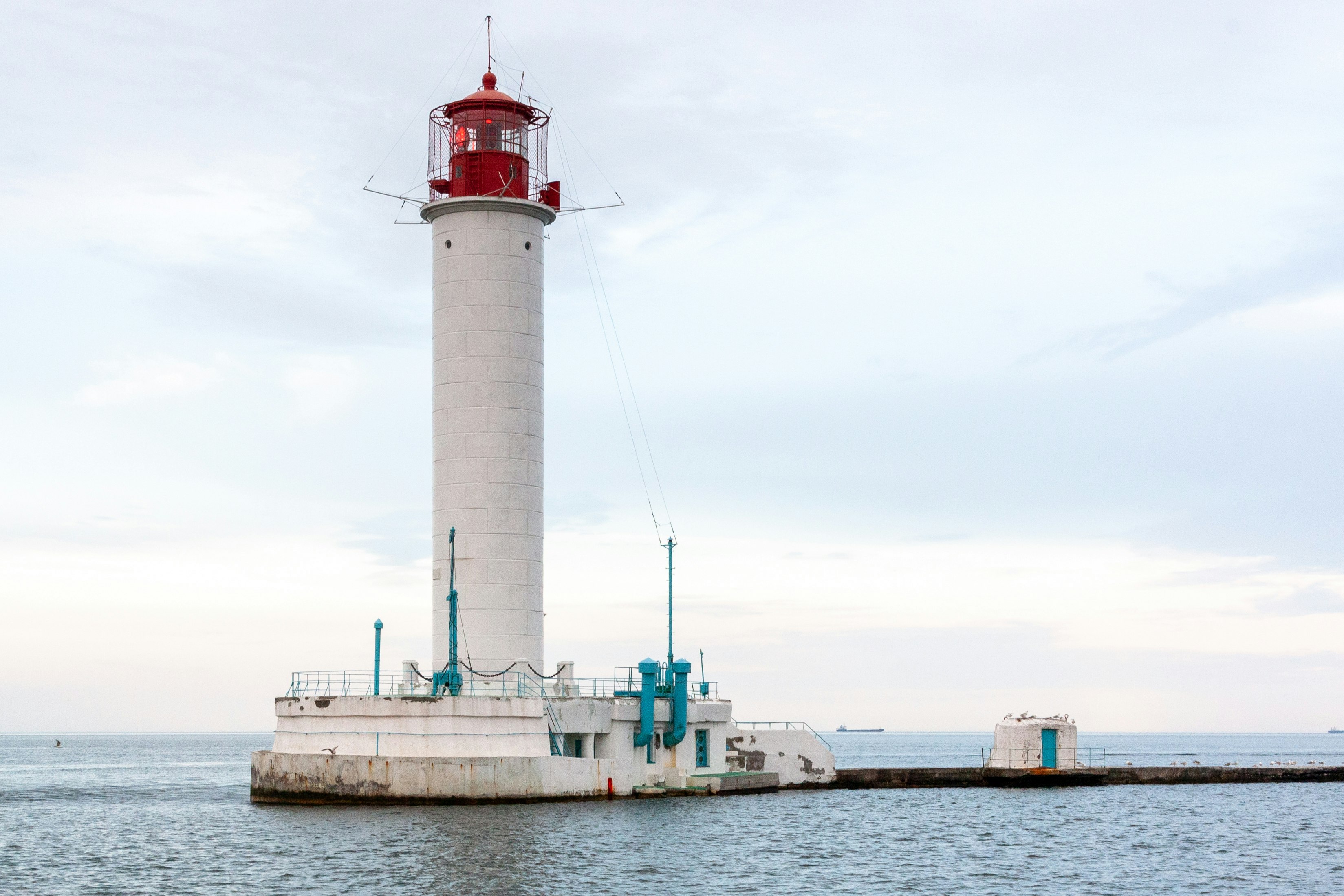 red and white lighthouse near body of water during daytime